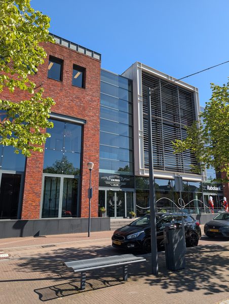 Voordeur van het gebouw met twee deuren; de linker deur is de juiste ingang.