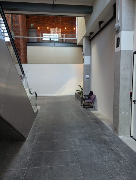 Lange gang; loop rechtdoor naar het einde en kijk dan naar rechts.